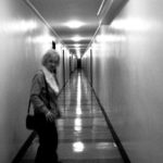 Women stands in a long corridor