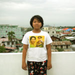 Young girl walks proudly as she wears a t-shirt with two of her idols, Aung San Suu Kyi and her father Aung San.