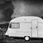 Caravan with the smoke and fire in the background