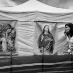 Woman passes along the images of Jesus posted on the tent