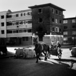 Teenagers ride a sulky through the street of the resident area of social blocks