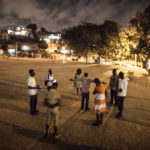 Young Africans pray at night at park