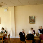 a group of elderly people sitting in the dining room