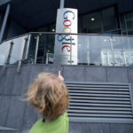 Girl points with her finger at the Google sign erected in front of the Google headquarters building