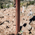 Standing person prays in front of the wooden cross in Medjugorje