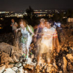 People walk at nighttime the rocky path at the Medjugorje pilgrimage site