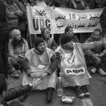 Young unemployed graduates sit on the ground in a protest in Tunis