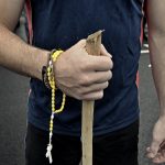 Hands with rosary and a walking stick