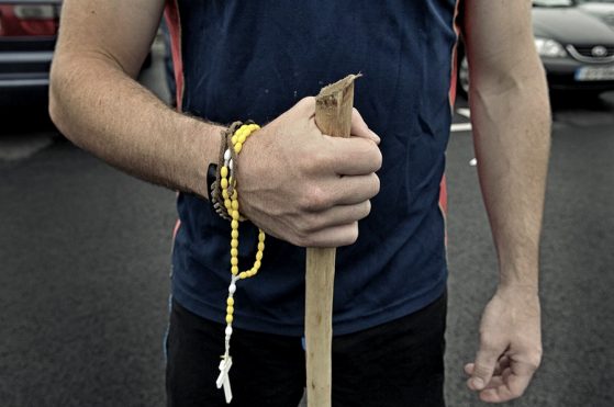 Hands with rosary and a walking stick