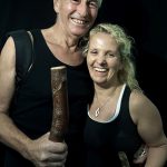 Portrait of middle age couple with walking sticks with black background