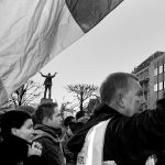 Man holds high the Irish flag at the anti-government-demonstration