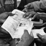 Men hold a paper documents with a portrait photo on it, Choucha refugee camp,Tunisia