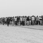 Big group of refugees walk along the road in a protest, Choucha refugee camp, Tunisia