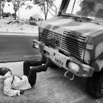 African refugee lying on the road trying to stop the military vehicle during the protest at the Choucha refugee camp, Tunisia