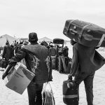 African refugees with suitcases walking into Choucha camp, Tunisia