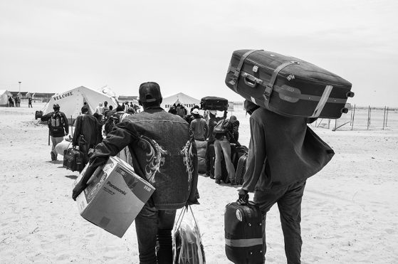 African refugees with suitcases walking into Choucha camp, Tunisia